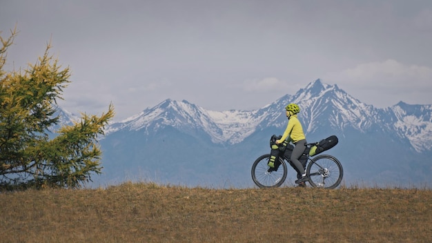 La mujer viaja en cicloturismo por terrenos mixtos con bikepacking El viaje viajero en bicicleta