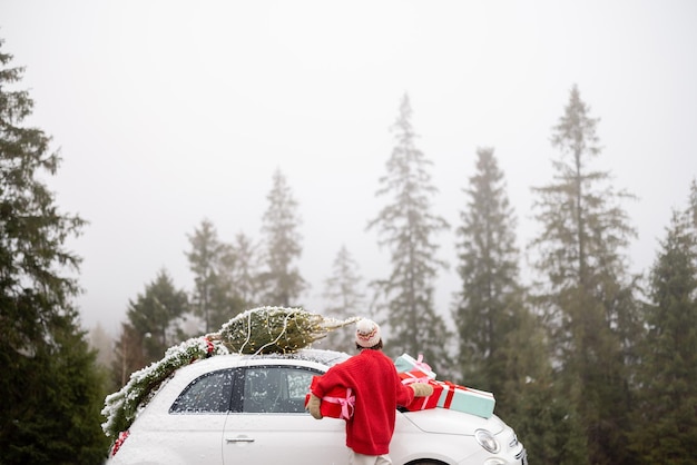 Mujer viaja en coche por las montañas durante las vacaciones de invierno