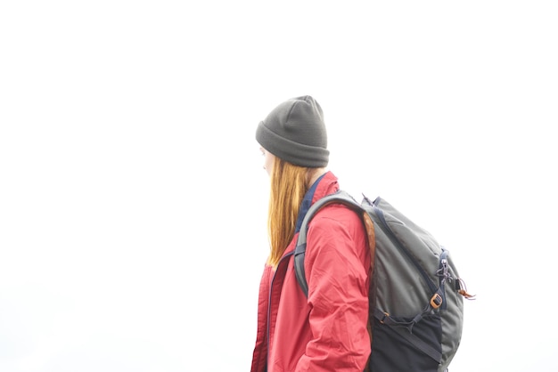 La mujer viaja en las montañas con una mochila en el clima de las nubes del paisaje de la tarde