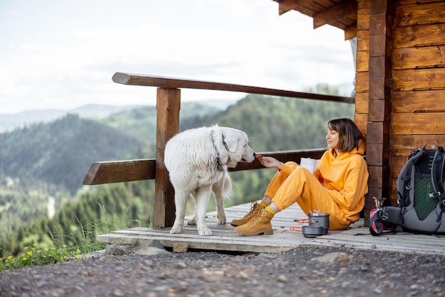 Mujer viaja con perro en las montañas.