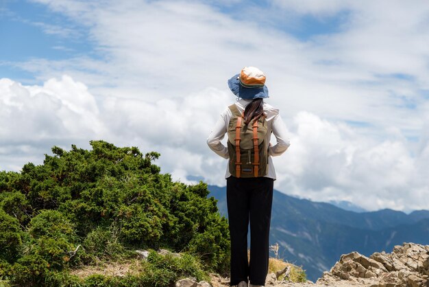 Mujer de viaje caminando por el sendero de senderismo sobre la montaña