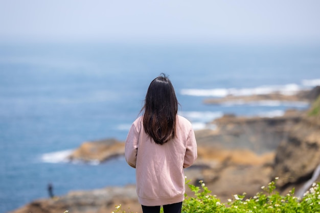 Mujer de viaje mira el mar