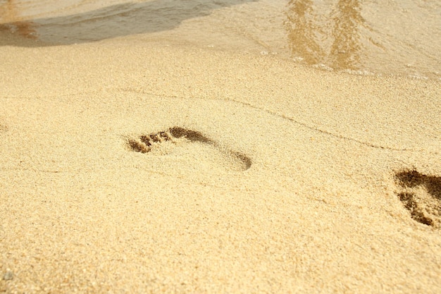 Una mujer de viaje en la playa relajándose caminando en una playa de arena dejando huellas en la arena Cerrar detalle de pies femeninos en arena dorada en una playa en Grecia Antecedentes