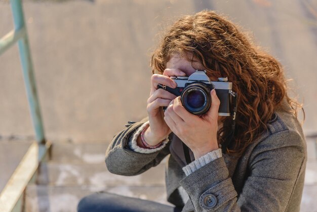 Mujer en un viaje toma fotos de la ciudad. mujer con una cámara. fotógrafa de mujeres