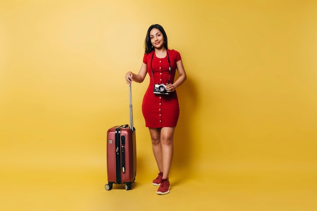 Mujer viajera adulta con una maleta y una cámara