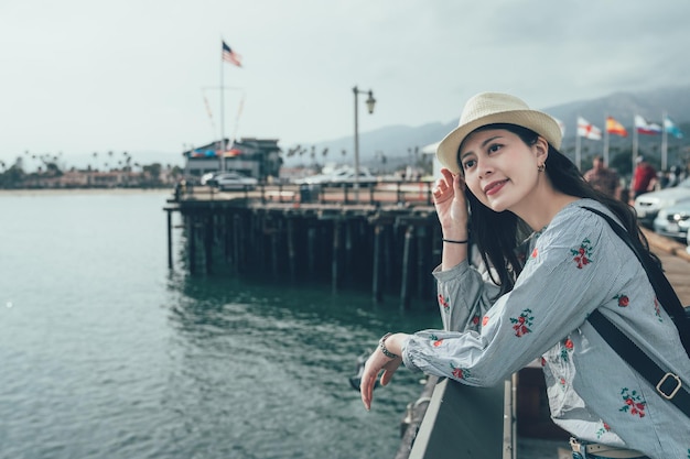 Mujer viajera barandilla inclinada en Stearns Wharf