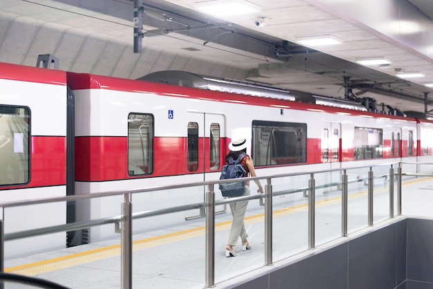 Mujer viajera caminando en la estación de trenConcepto de seguro de viaje