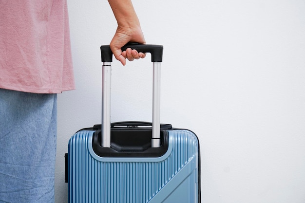 Foto mujer viajera caminando con una maleta.