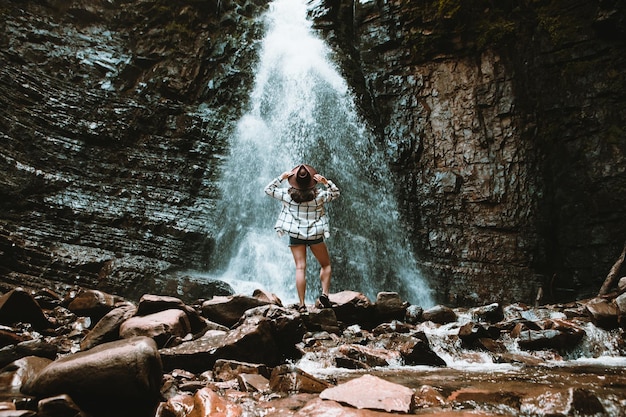 Mujer viajera disfrutando de la vista del espacio de la copia de la cascada