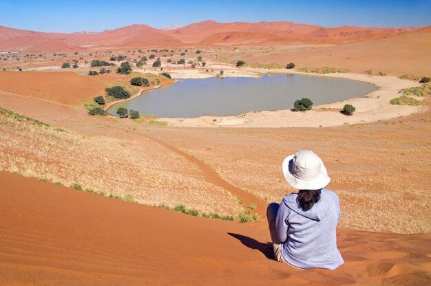 Mujer viajera en África, vacaciones en Namibia, mirando el hermoso paisaje del desierto de Namib