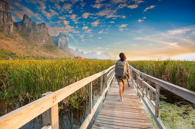 Mujer viajera de la libertad de pie con los brazos levantados y disfrutando de una hermosa naturaleza y animando a los jóvenes