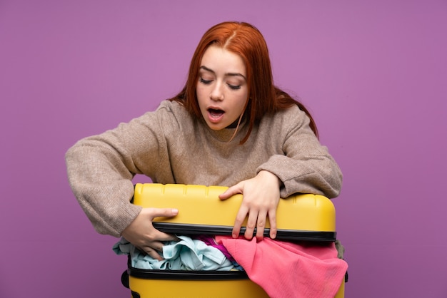 Mujer viajera con una maleta llena de ropa