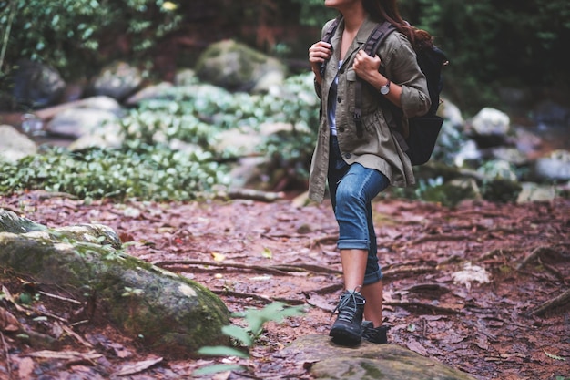 Foto una mujer viajera con mochila caminando por el bosque.