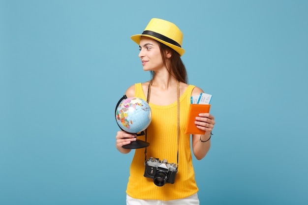 Mujer viajera en ropa casual de verano amarillo y sombrero con boletos de globo en azul