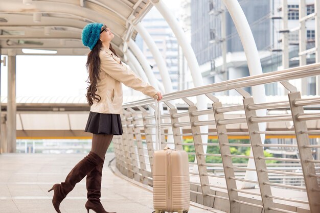 Mujer viajera sosteniendo una maleta de equipaje en el aeropuerto durante el viaje de viaje para el concepto de mujer