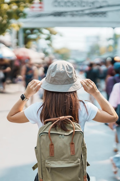 Foto mujer viajera de visita en bangkok turista con mochila y sombrero de turismo en el mercado de fin de semana de chatuchak, punto de referencia y atracciones populares en bangkok tailandia viajes en el concepto del sudeste asiático