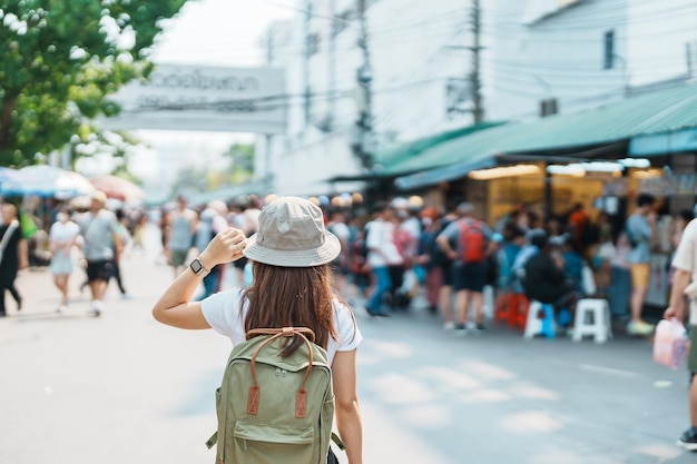 Mujer viajera de visita en Bangkok Turista con mochila y sombrero de turismo en el mercado de fin de semana de Chatuchak, punto de referencia y atracciones populares en Bangkok Tailandia Viajes en el concepto del sudeste asiático