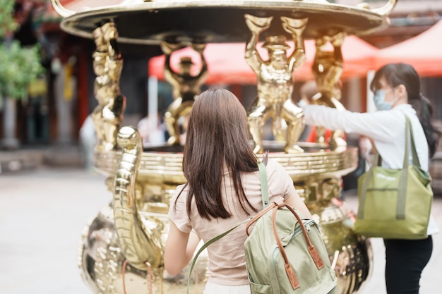 Mujer viajera de visita en Taiwán Turista con sombrero de turismo en el Templo Longshan Templo religioso folclórico chino en el distrito de Wanhua Punto de referencia de la ciudad de Taipei y concepto popular de viajes y vacaciones