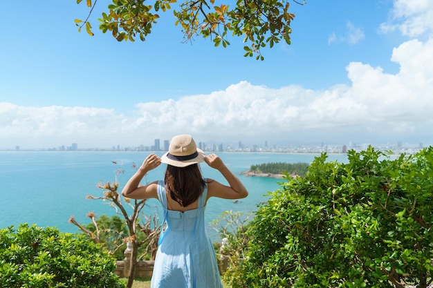 Mujer viajera visitando la vista de la ciudad de Da Nang Turista con vestido azul y sombrero viajando en la península de Son Tra Vietnam y el concepto de viaje del sudeste asiático