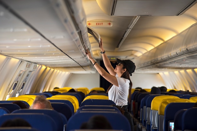 Mujer de viajero abrir taquilla arriba en avión