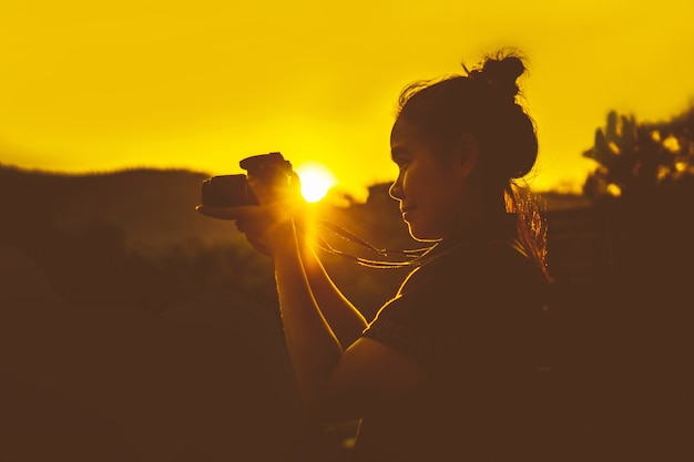 Mujer viajero Fotógrafo paisaje al aire libre Silueta al atardecer