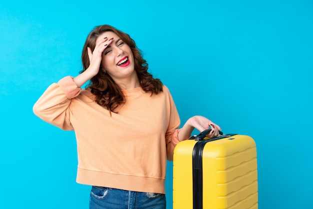 Mujer de viajero con maleta sobre risa aislada