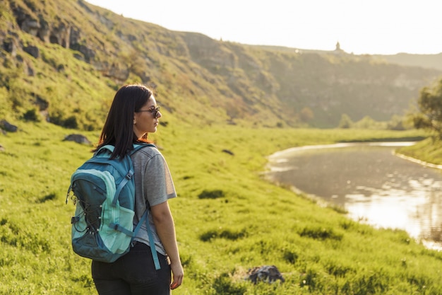 Mujer viajero con mochila en el campo de naturaleza verde