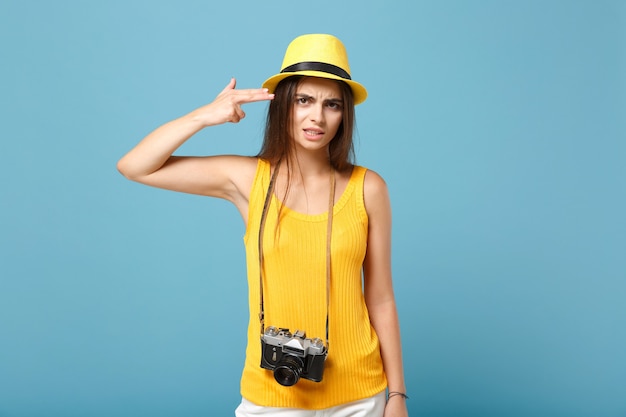 Mujer viajero en ropa casual de verano amarillo y sombrero con cámara de fotos en azul