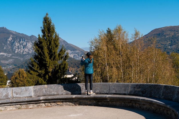 Mujer viajero tomando fotografías con su teléfono móvil de las montañas de Saint Savin Francia