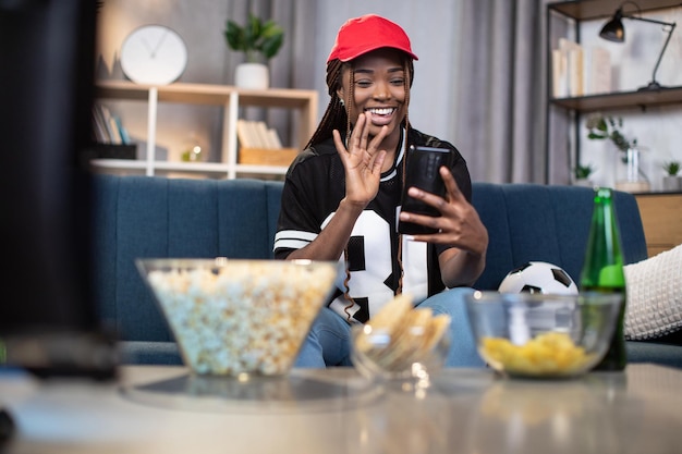 Mujer con videochat en el móvil durante la visualización del fútbol