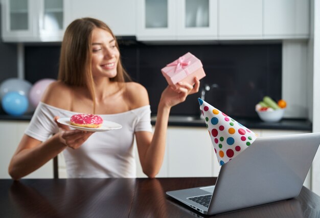 Mujer con videollamada para celebrar cumpleaños en casa