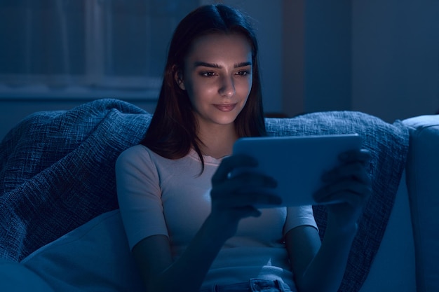 Mujer viendo video en tableta por la noche