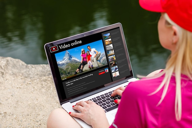 Mujer viendo videos en línea en una computadora portátil.