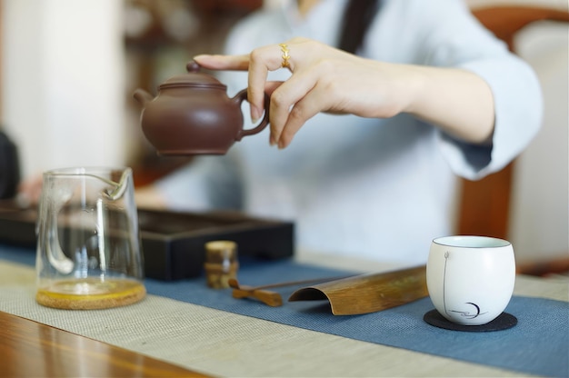 Una mujer vierte una taza de té de una tetera en una mesa Bebiendo té en silencio