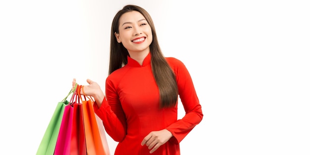 Mujer vietnamita con ao dai y bolsa de compras