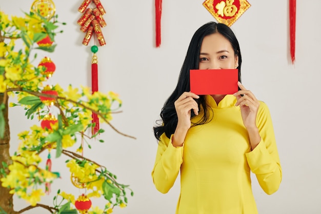 Foto mujer vietnamita mostrando sobre rojo