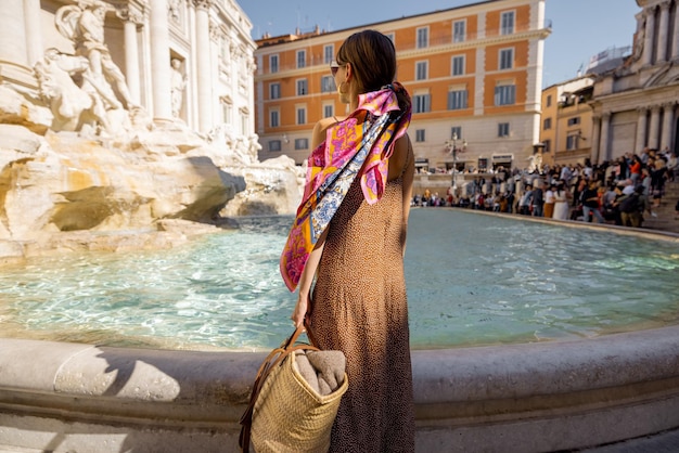 Mujer visitando la famosa fuente di trevi en roma