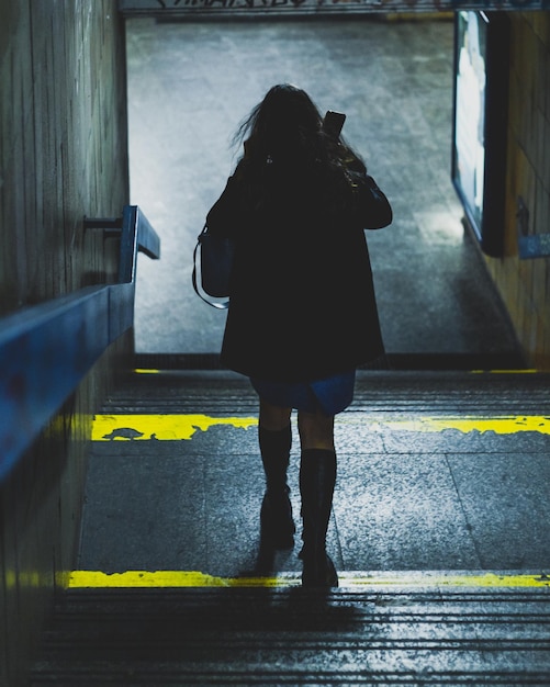 Foto mujer vista desde atrás en el pasaje subterráneo