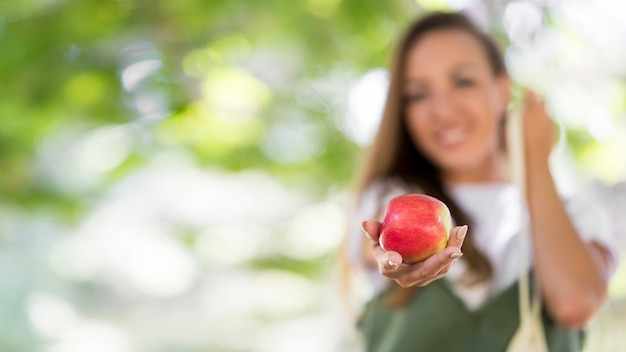 Mujer de vista frontal sosteniendo una manzana con espacio de copia