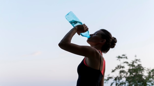 Foto mujer de vista lateral, agua potable