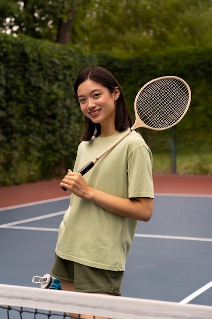 Foto mujer de vista lateral en el campo de bádminton