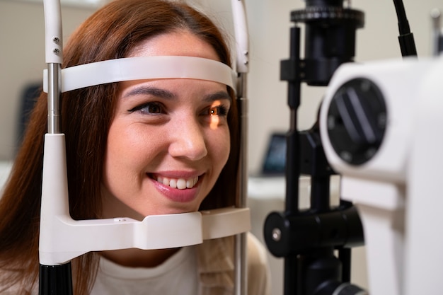 Mujer de vista lateral haciéndose revisar los ojos