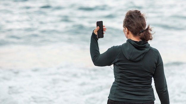 Mujer de vista trasera tomando selfie