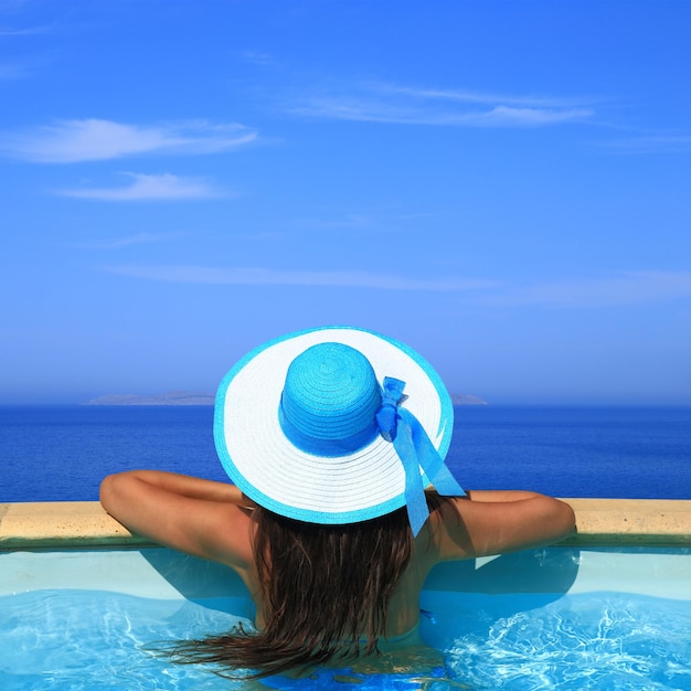 Mujer con vistas al mar desde la piscina