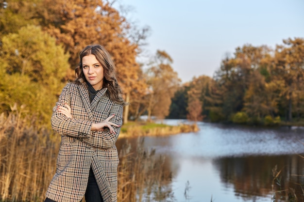 Mujer vistiendo un abrigo y de pie en el parque