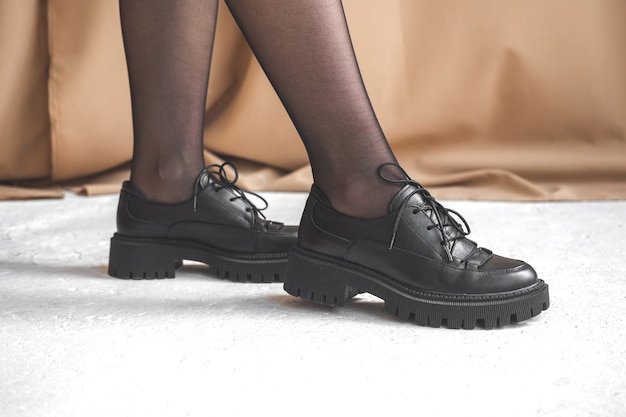 Mujer vistiendo botas de combate, zapatos negros en las piernas de la mujer, foto de estudio, preson femenino detrás de la escena de la foto del concepto