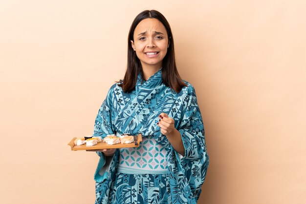 Mujer vistiendo kimono y sosteniendo sushi