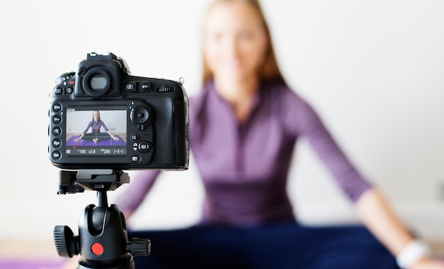 Mujer vlogger grabando deportes relacionados con la transmisión en casa