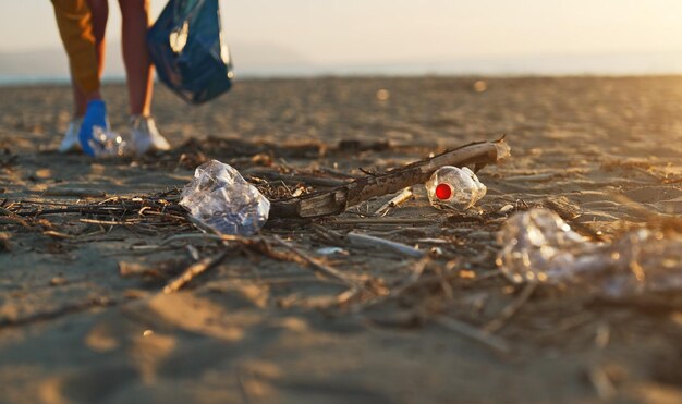Foto mujer voluntaria recoge la basura en la playa la contaminación ambiental
