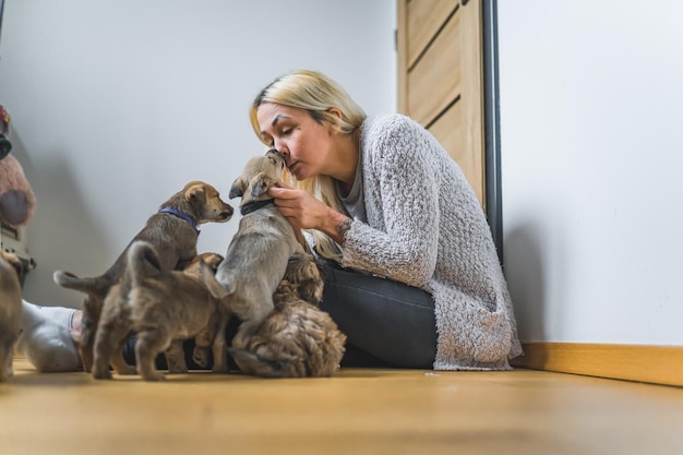 Mujer voluntaria con sus cachorritos rescatados en casa